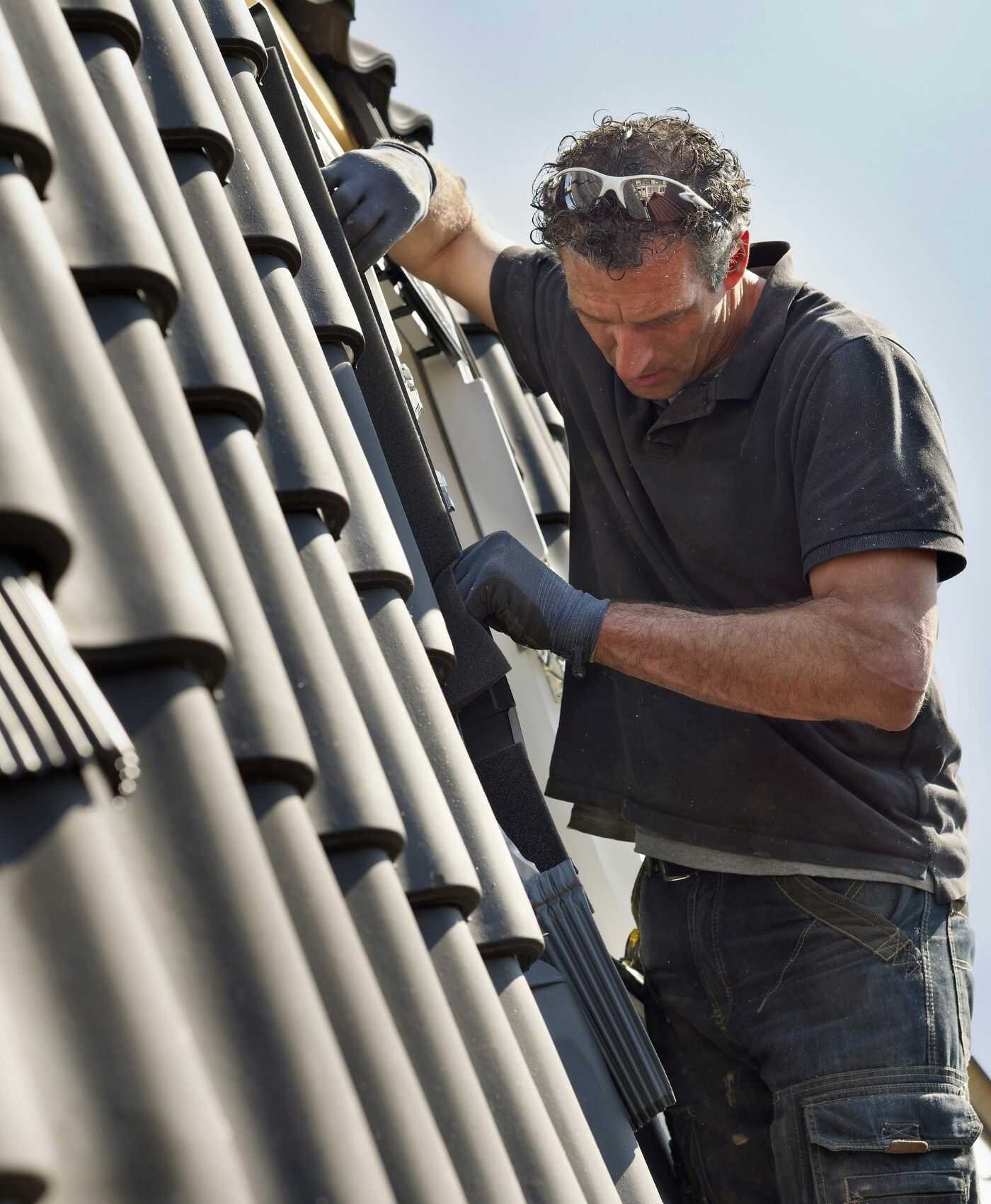Dakwerker aan het werk op een hellend dak