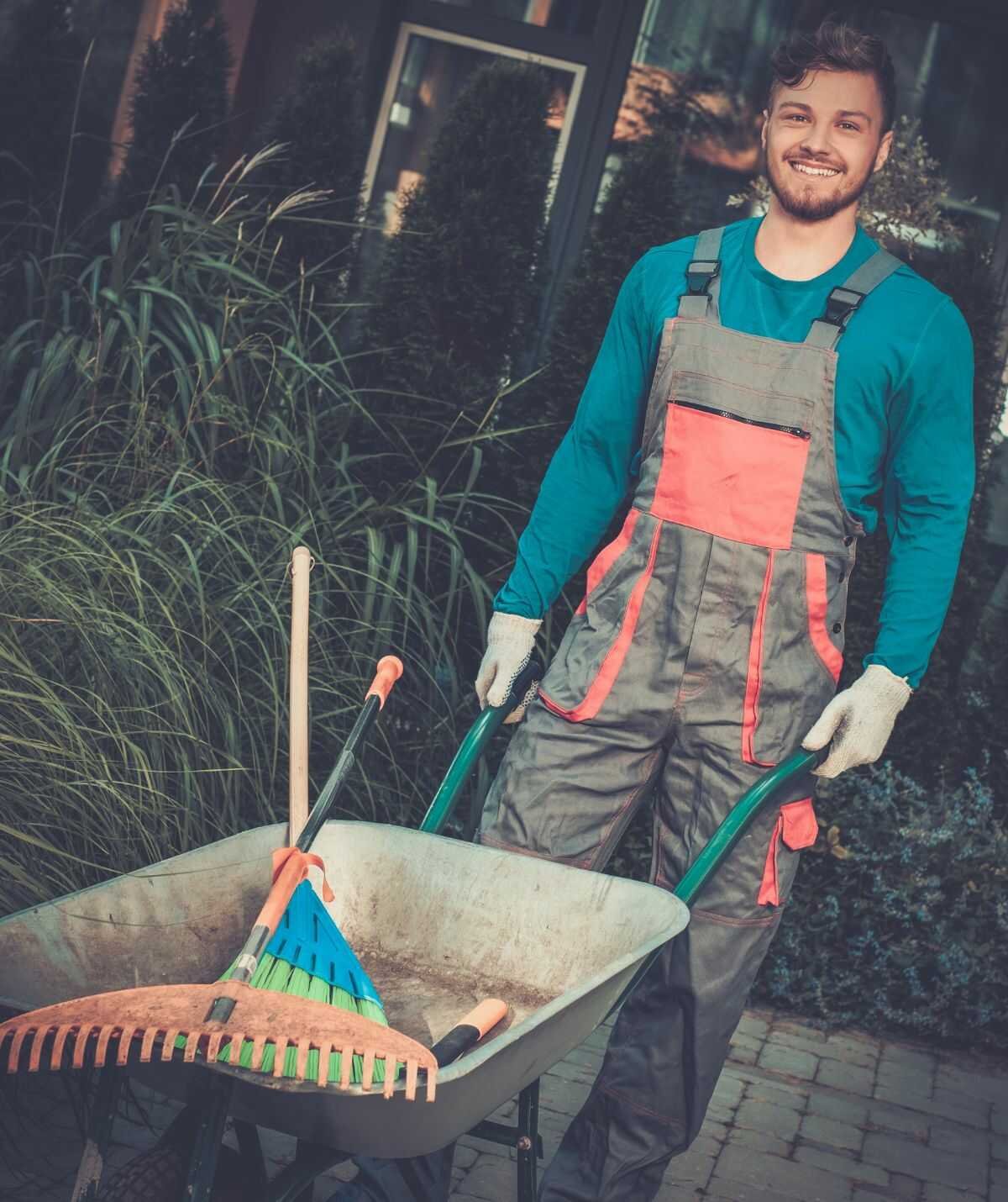 Tuinaannemer legt een terras aan met een minigraver op de achtergrond